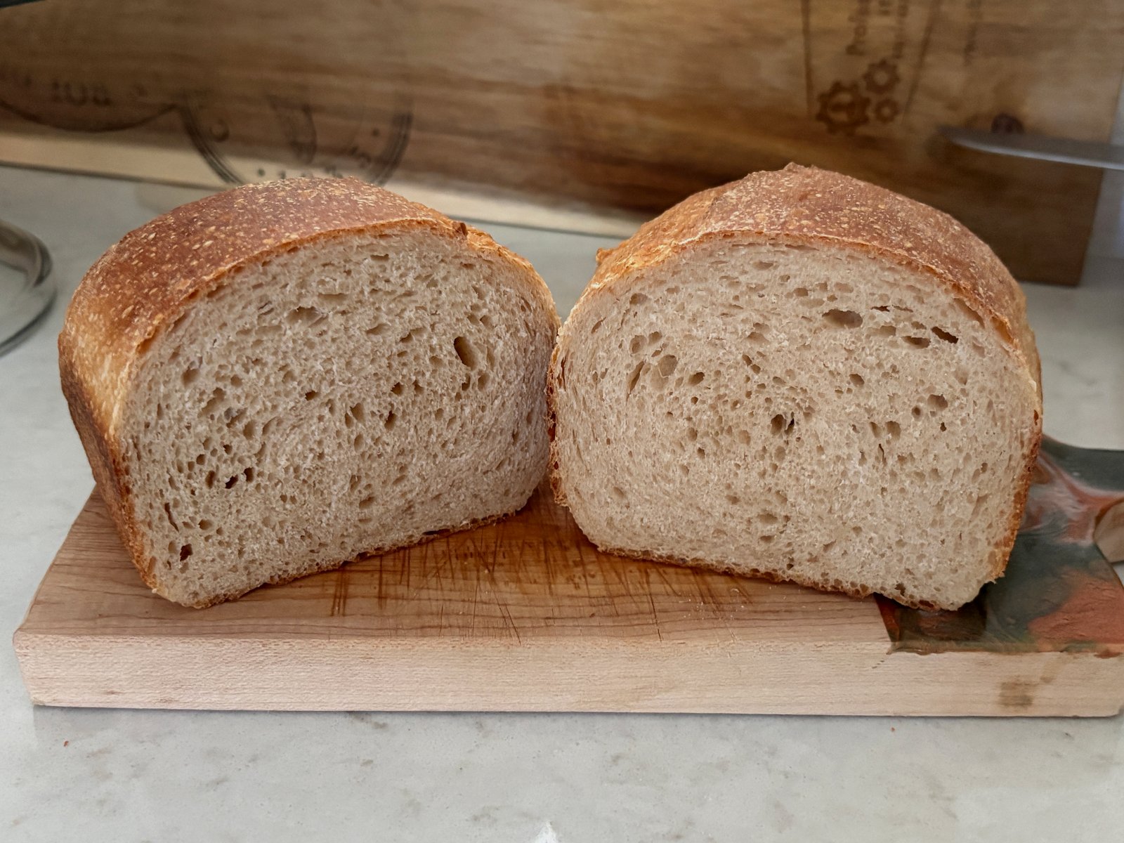 Two halves of a milk sourdough sandwich loaf with an even small-holed crumb